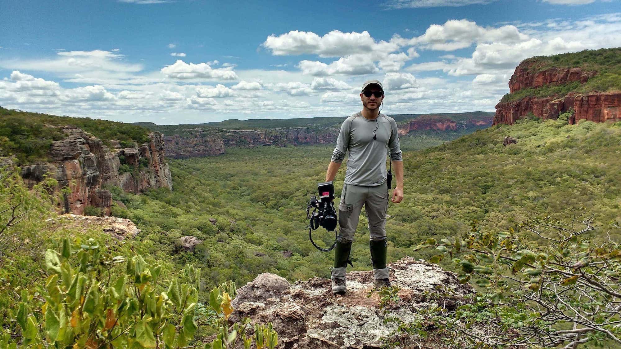 Diretor com camera na mão no meio da floresta brasileira Nikolas Fonseca filma documentário para o discovery networks